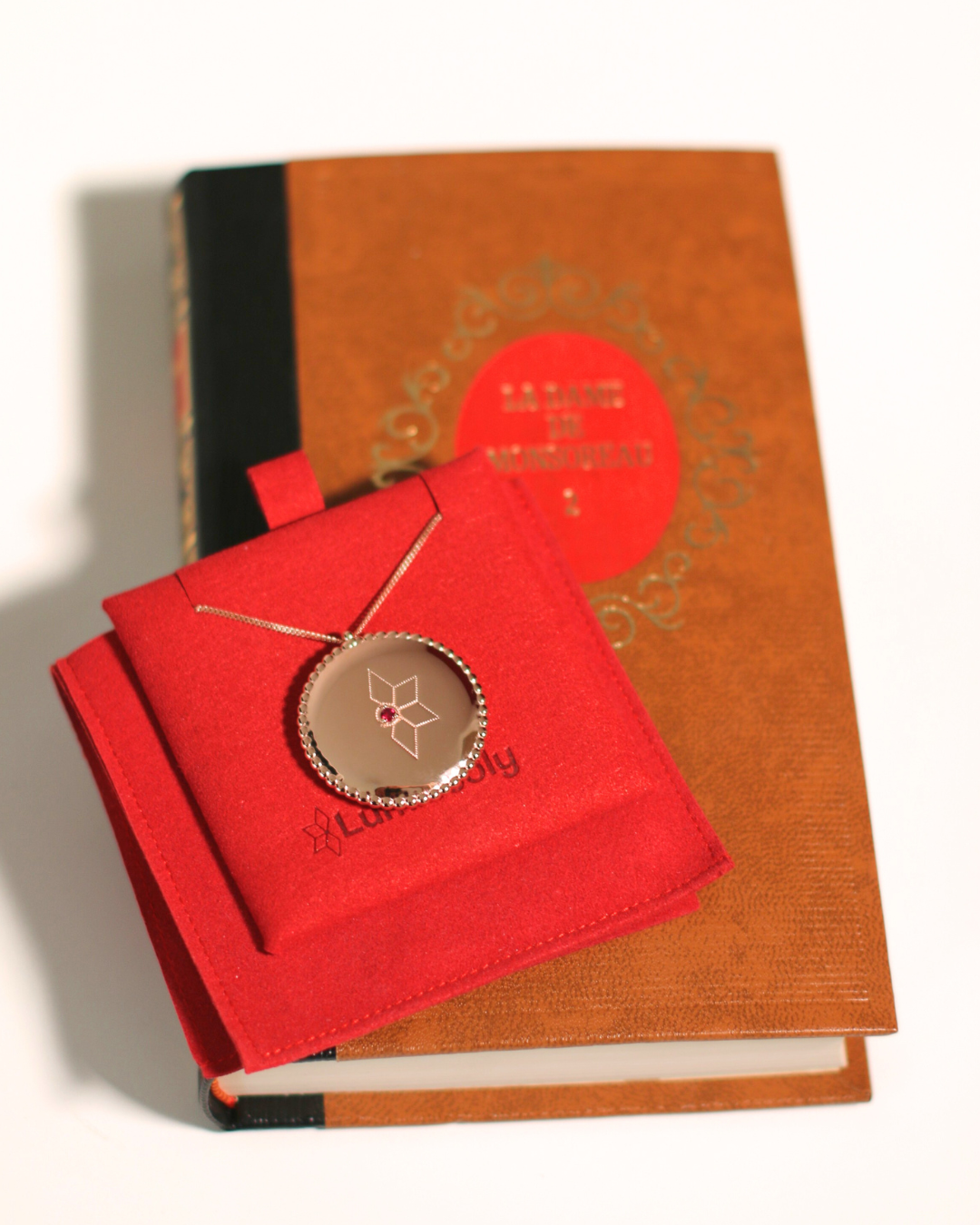 Le médaillon celeste rubis, accompagné de son livre packaging.